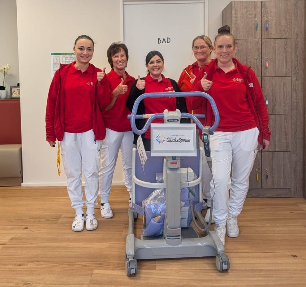 Eine Gruppe Pflegerinnen mit einer Hebehilfe 