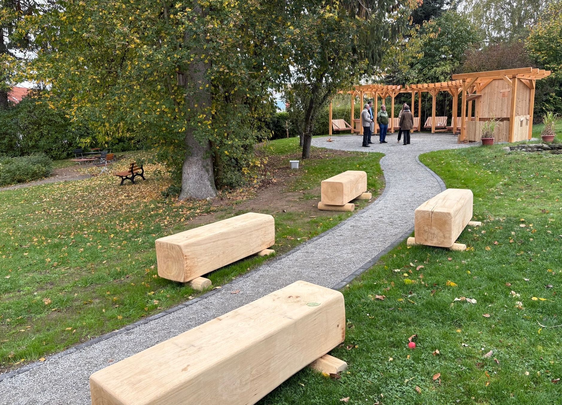Garten mit Holzblöcken und Pergola