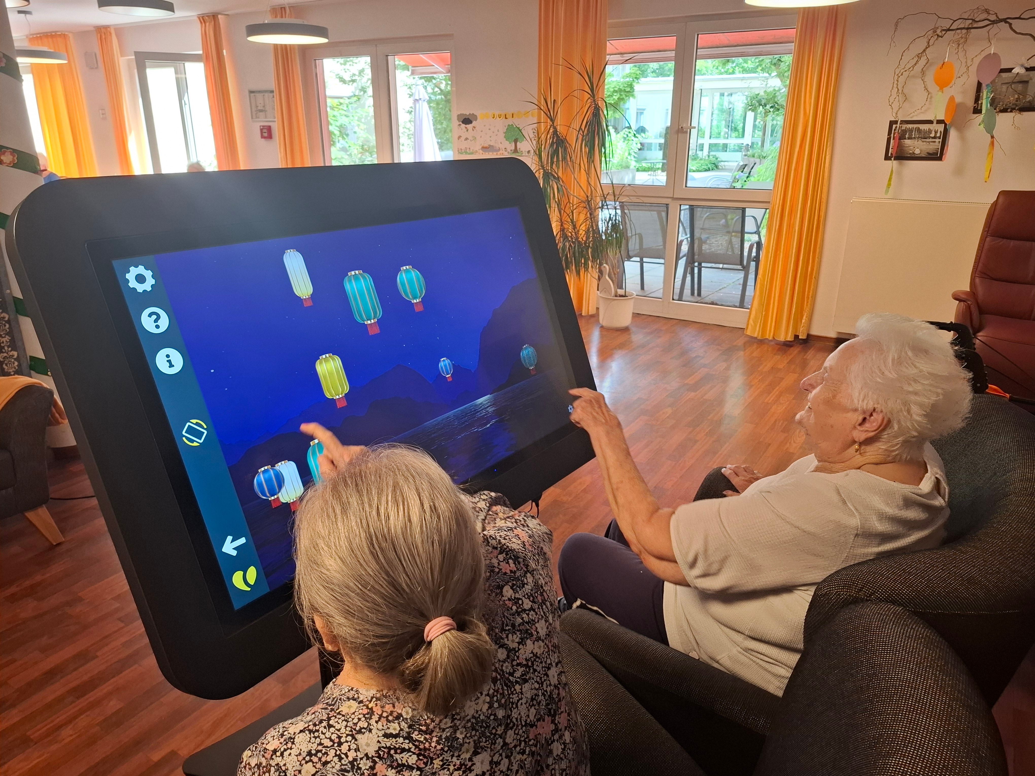 Zwei Seniorinnen am digitalen Aktionstisch