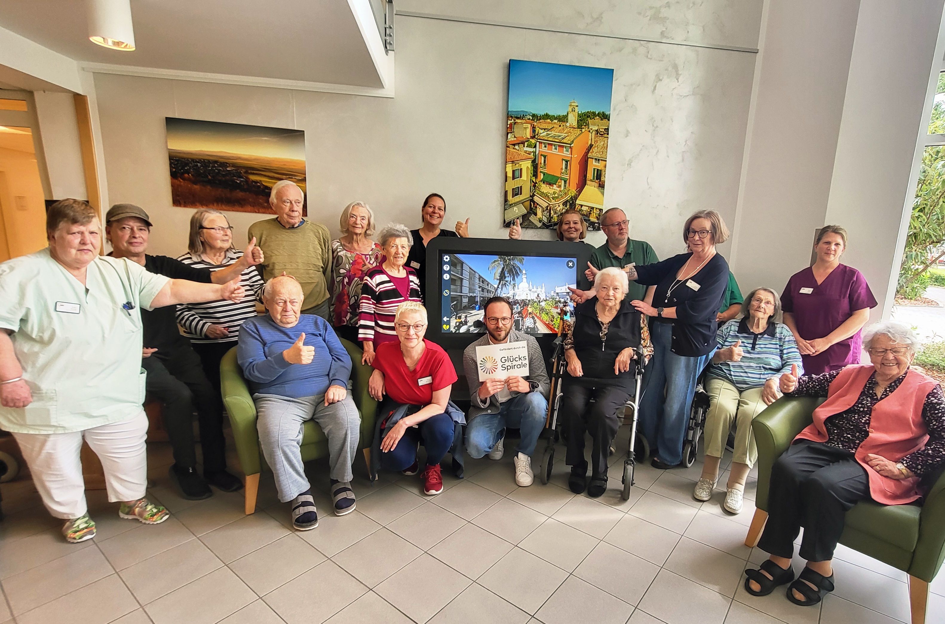 Eine Gruppe Seniorinnen und Senioren mit Pflegekräften