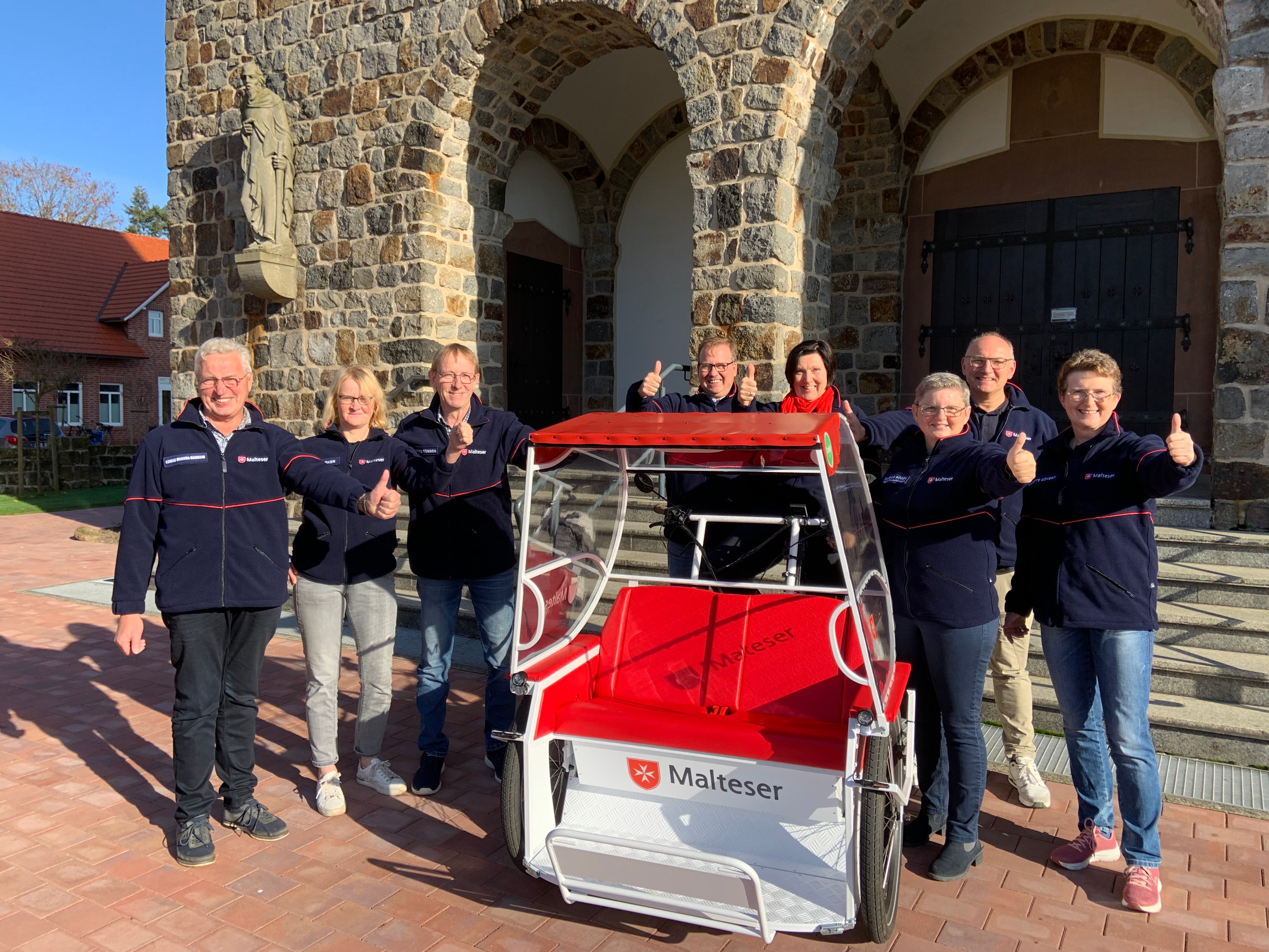 Eine Gruppe Menschen mit einer Rikscha