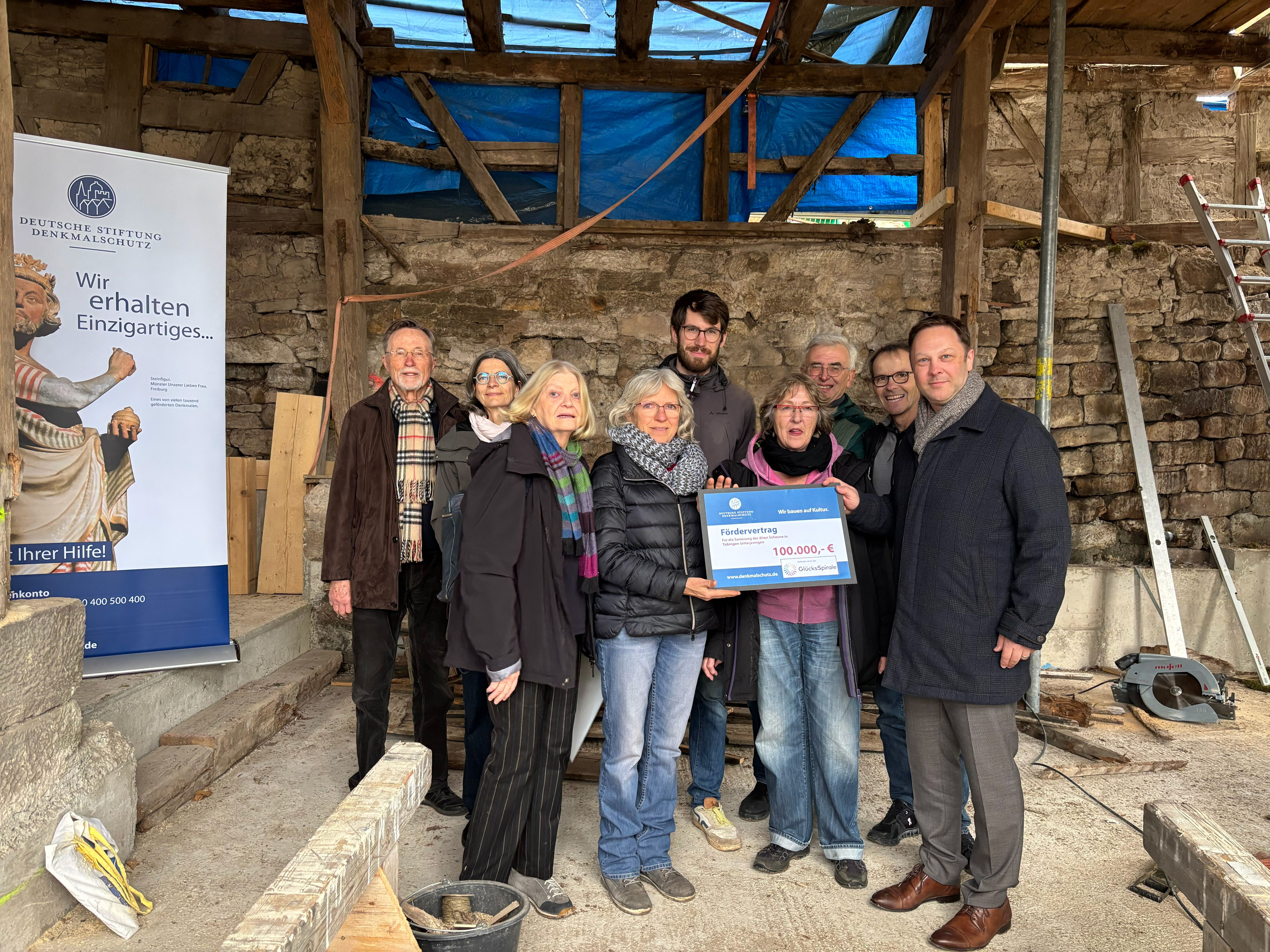 Eine Gruppe Menschen mit Förderscheck auf einer Baustelle