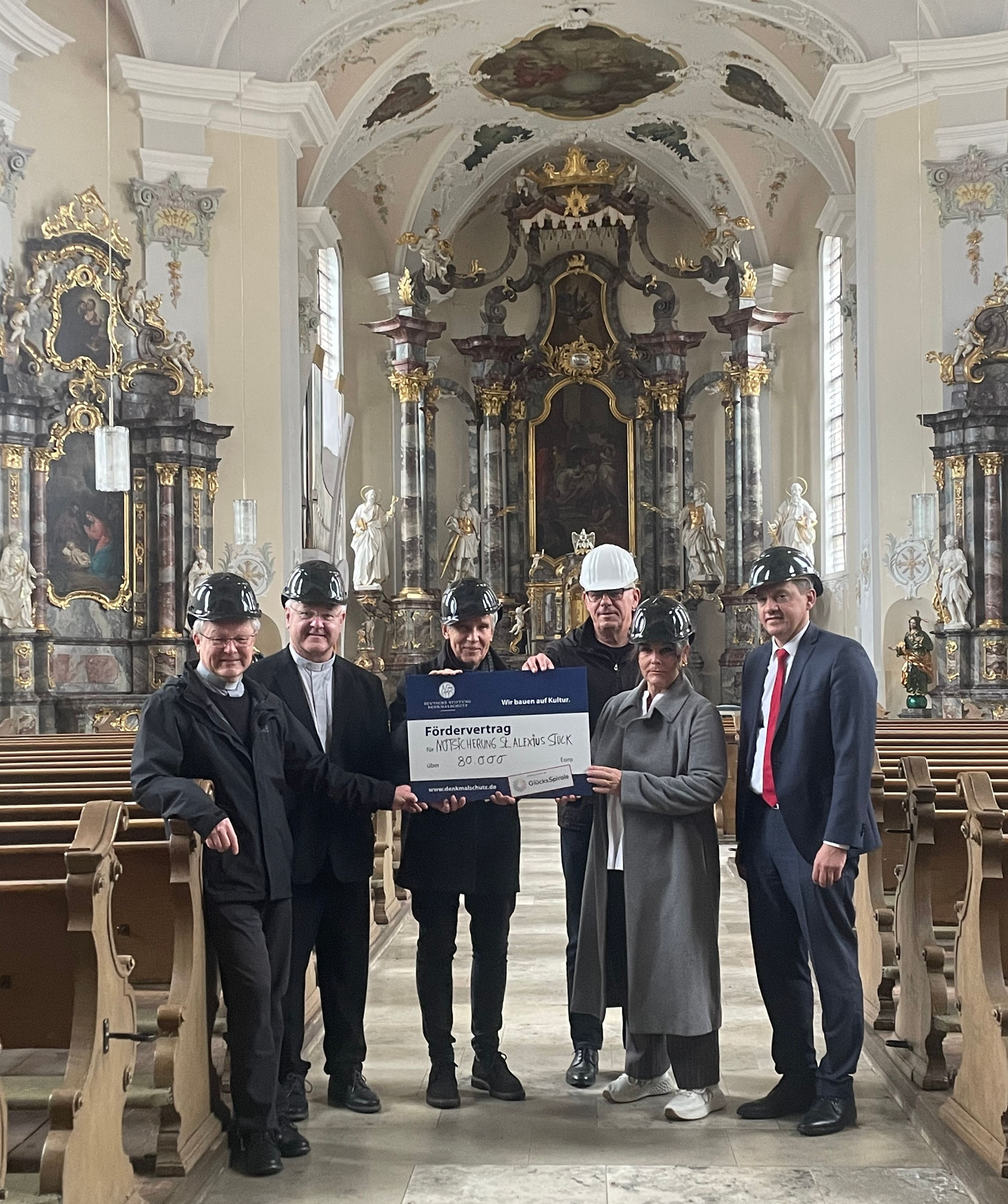 Eine Gruppe Menschen mit Förderscheck in einer Kirche