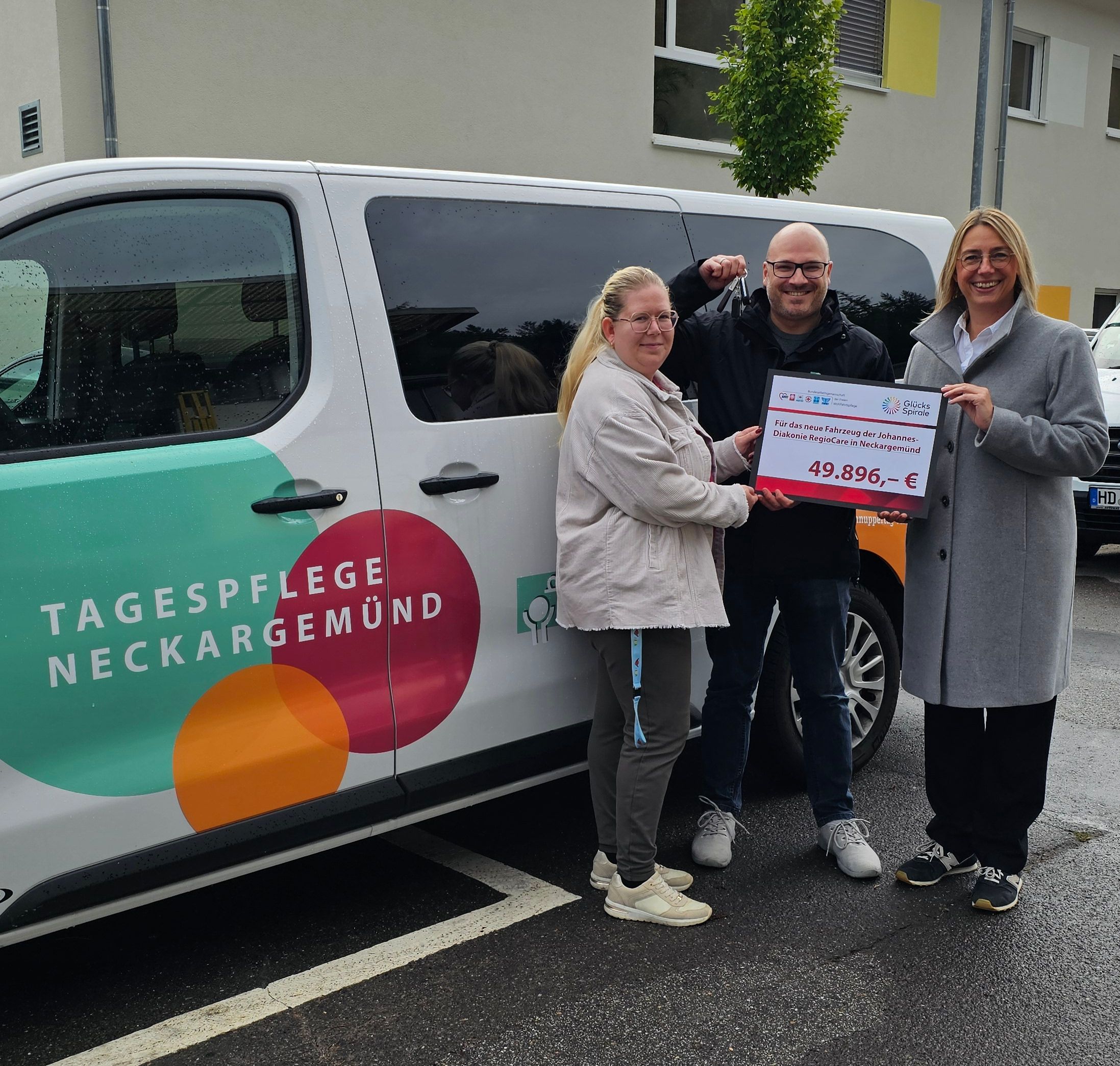 Eine Gruppe Menschen mit Förderscheck vor einem Kleinbus