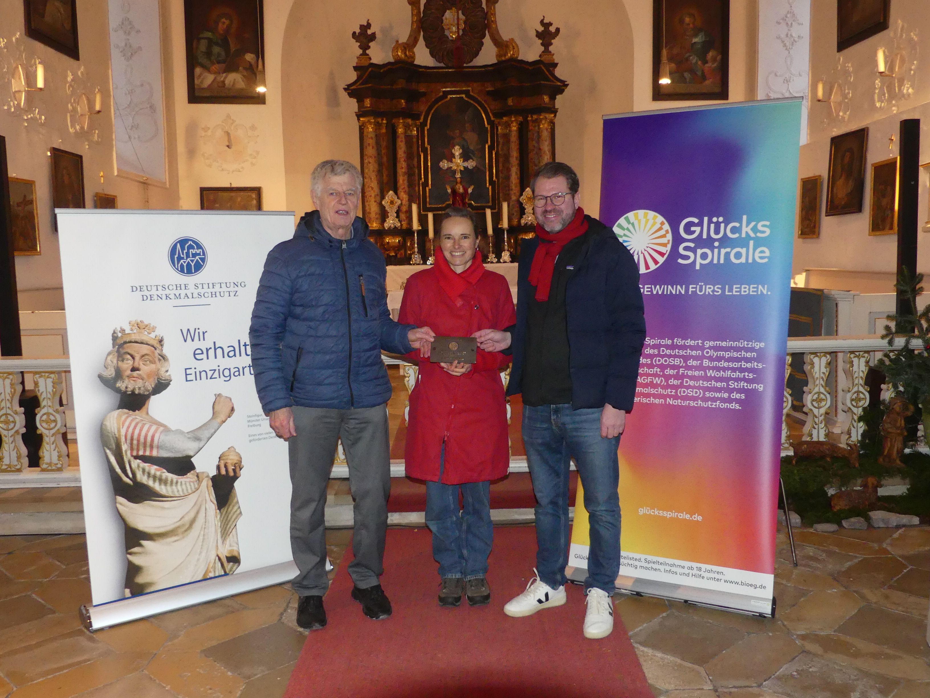 Eine Gruppe Menschen mit Bronzeplakette