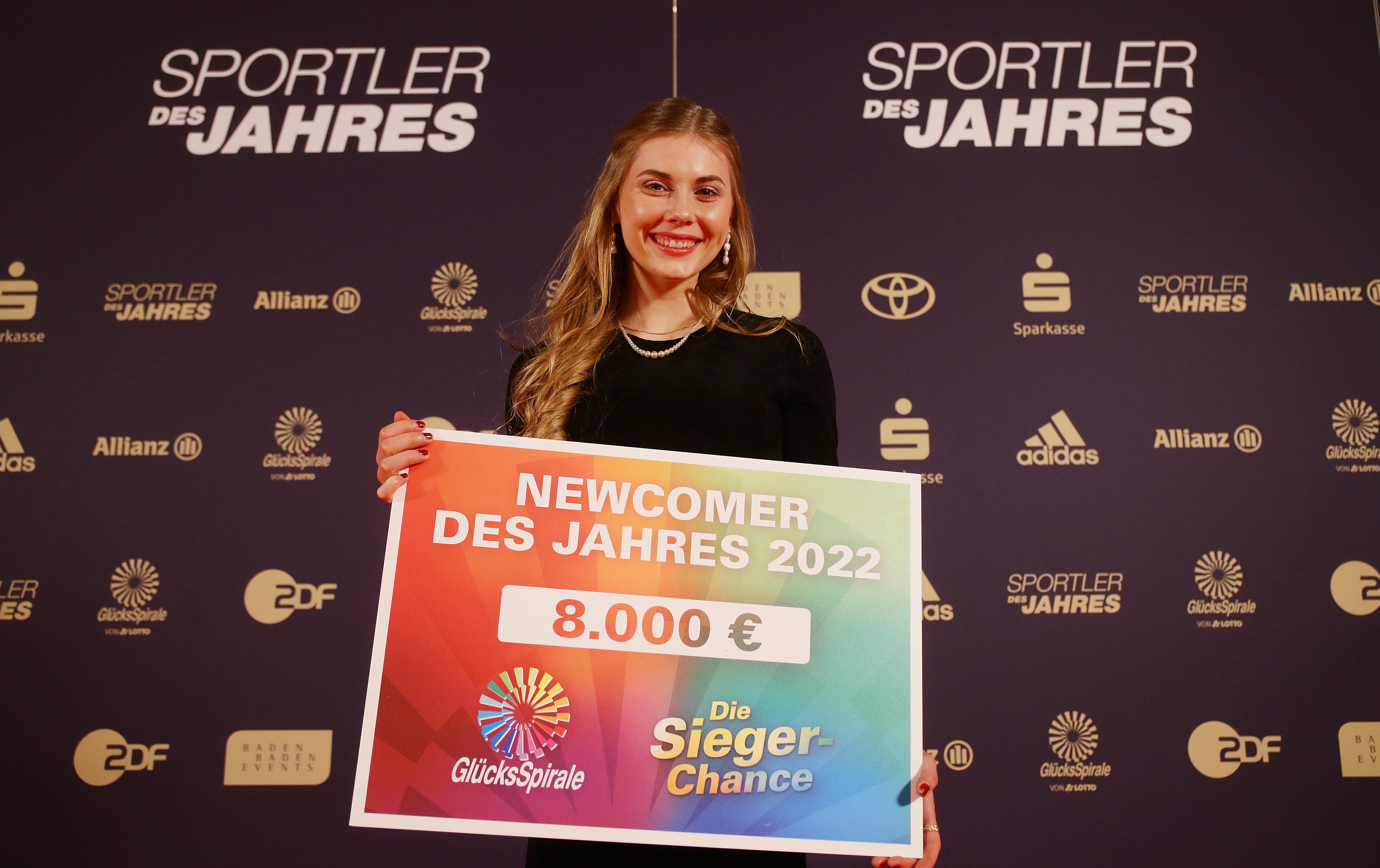 Frau hält einen Scheck in der Hand