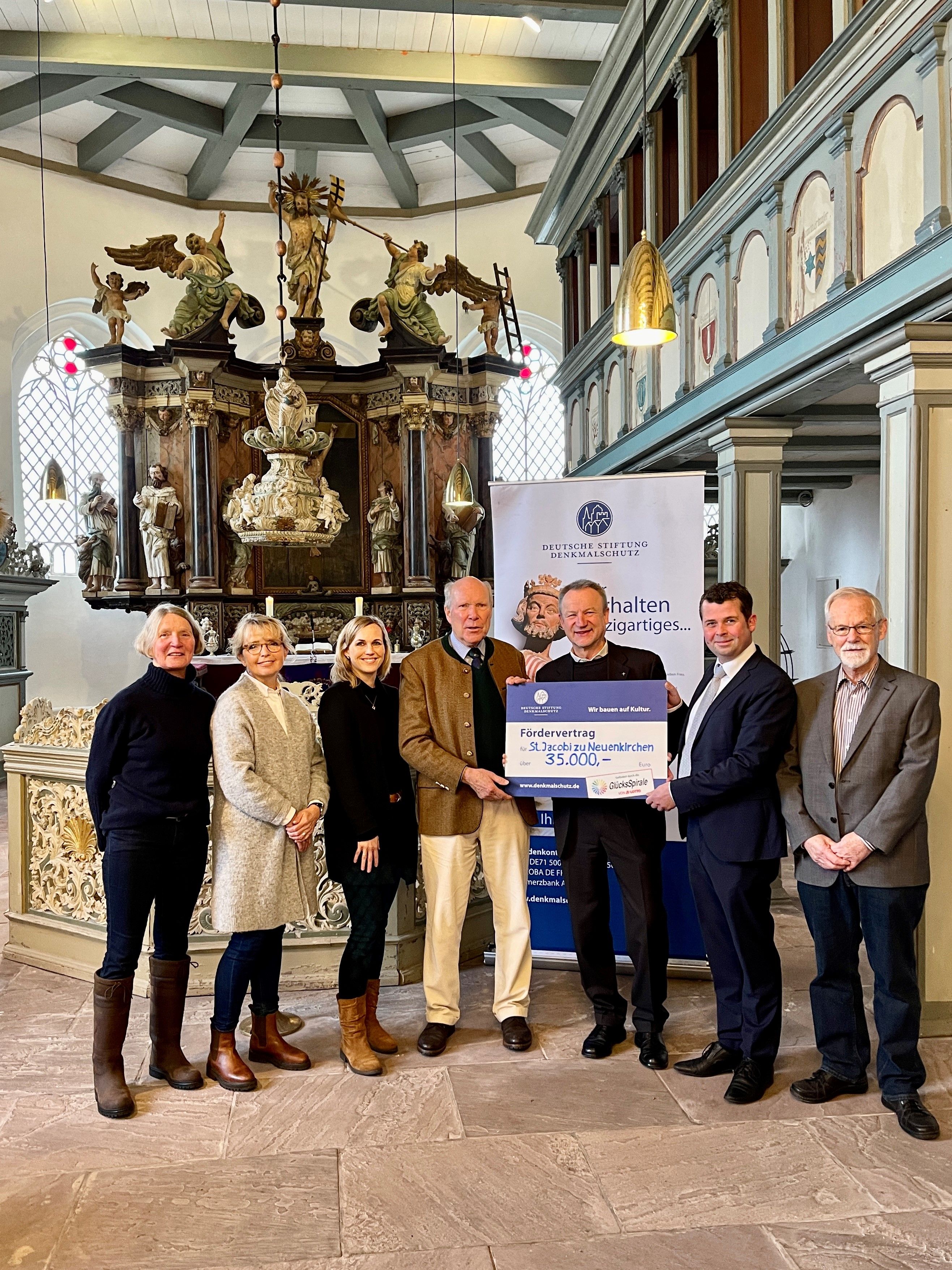 Eine Gruppe Menschen mit Förderscheck in einer Kirche