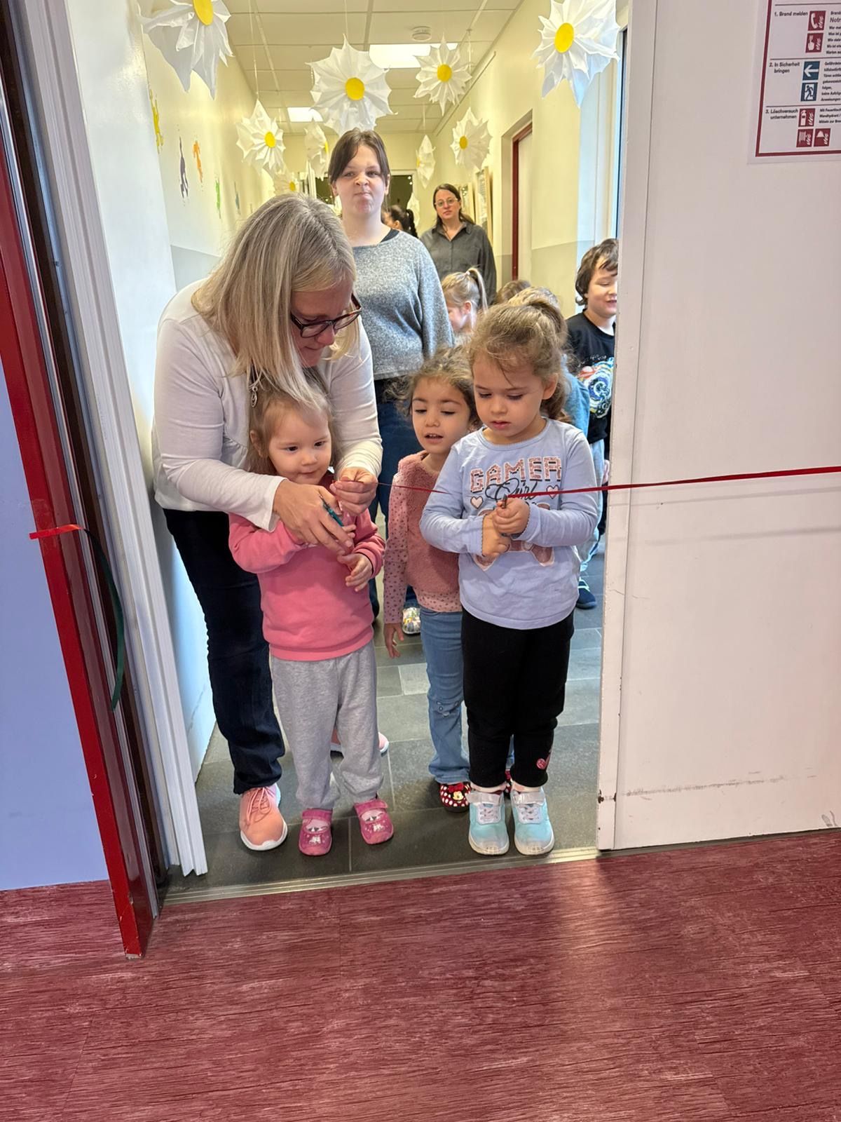 Kinder die ein rotes Band zur Eröffnung durchschneiden